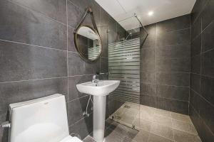 a bathroom with a sink and a mirror and a toilet at 광안비치호텔더엠 in Kwangan-dong