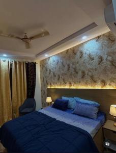 een slaapkamer met een blauw bed en een muur bij Love passion in Greater Noida