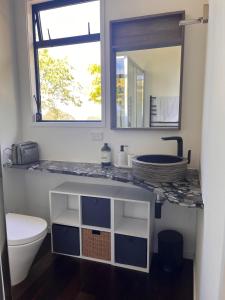 Un baño con lavabo, inodoro y espejo. en Paradise Found at Studio 65, en Hamurana 23 fotos más