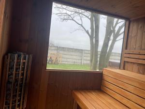 una ventana en una habitación de madera con un árbol en Villa Bodiky, en Bodíky
