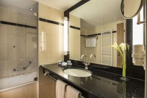 
a bathroom with a sink and a mirror at Maritim Hotel Dresden in Dresden
