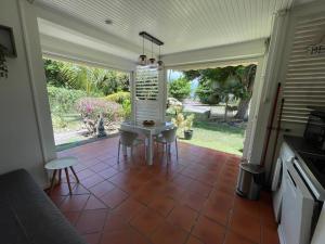a kitchen with a table and chairs on a patio at Ti coin de paradis Anse des Rochers in Saint-François