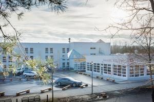 a large white building with cars parked in a parking lot at Kurhotel Pyramide Sibyllenbad in Neualbenreuth