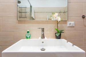un lavandino bianco in un bagno con uno specchio di Amedeo Apartment a Roma