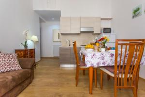 - une cuisine et une salle à manger avec une table et un canapé dans l'établissement Amedeo Apartment, à Rome