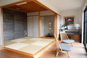 a living room with two chairs and a closet at Rairin in Hiroshima