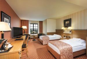 a hotel room with two beds and a desk at Maritim Hotel Dresden in Dresden