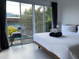 ein Schlafzimmer mit einem Bett und einem großen Fenster in der Unterkunft 2 Bed 2 Bath Private Pool Villa Near Beach in Nathon Bay + 40 Fotos