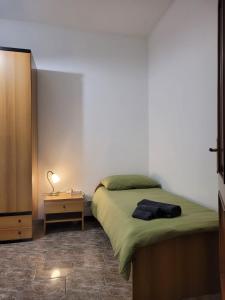 een slaapkamer met een bed en een nachtkastje met een lamp bij La casa di Sergiò in Belgioioso