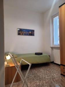 een slaapkamer met een groen bed, een bureau en een raam bij La casa di Sergiò in Belgioioso