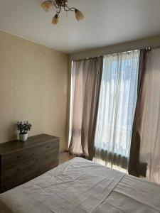 Un dormitorio con una cama y una ventana grande. en Apartmant in Smart Plaza, en Kiev 31 fotos más