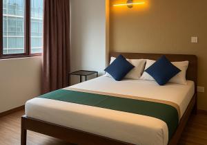 a bedroom with a large bed with blue pillows at Arrival View in Male City