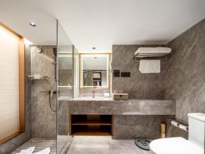 広州市にあるGuangdong Hotelの洗面台とシャワー付きのバスルーム