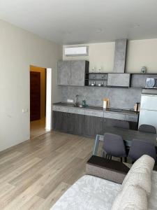 Una sala de estar con una mesa y una cocina. en Apartmant in Smart Plaza, en Kiev