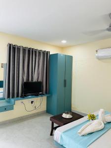a bedroom with a blue cabinet and a television at GOKUL Hotel in Maheshwar +25 photos