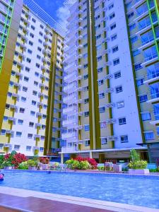 uma piscina em frente a dois prédios altos em MesaVerte Residence em Pontud