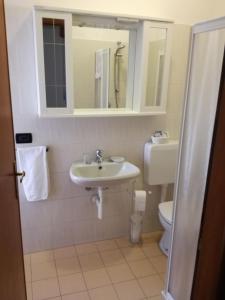 ein Badezimmer mit einem Waschbecken, einem WC und einem Spiegel in der Unterkunft San Giorgio Lazise in Colà di Lazise