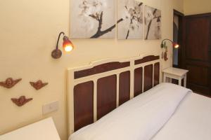 a bedroom with a bed with a wooden headboard at Villa Eleanto in Cefalù +37 photos