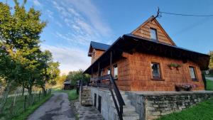 a small wooden house with a gambrel roof at Koronkowa Chatka w Beskidach in Istebna
