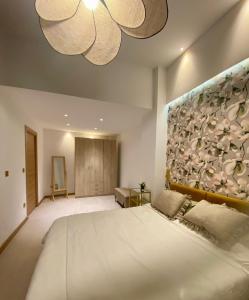 a bedroom with a large white bed and a painting on the wall at Castro Romano VUT 7712 AS in Gijón