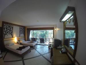 Una gran sala de estar con un sofá y una mesa. en River Kwai Village Hotel, en Ban Kaeng Raboet