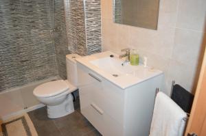 a white bathroom with a toilet and a sink at Margarita Apartment Benidorm in Benidorm