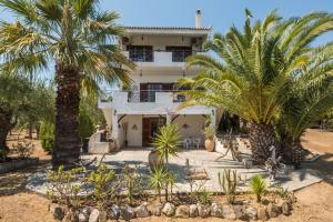 a house with palm trees in front of it at Villa Mariana in Koroni