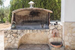 a stone fireplace with a bench in front of a building at Villa Mariana in Koroni