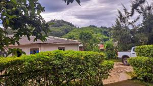 Ein weißer Truck parkt vor einem Haus. in der Unterkunft New Casa Gorilla Lodge and Campsite in Kisoro