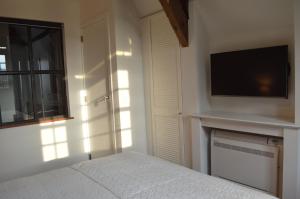sypialnia z łóżkiem i telewizorem z płaskim ekranem w obiekcie De Waterzooi Lodge w Gandawie