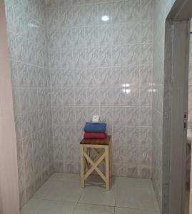 een badkamer met een witte tegelwand en een toilet. bij JEK Villa in Brufut +7 foto's