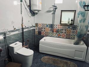 a bathroom with a toilet and a tub and a sink at Ha Giang Uphill Coffee Farmstay in Ha Giang