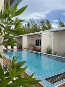a swimming pool in front of a house at Manta Beach Retreat in Hikahera