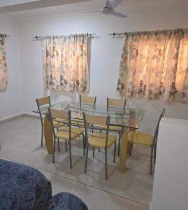 een eetkamer met een glazen tafel en stoelen bij JEK Villa in Brufut