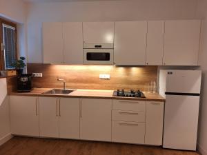 a kitchen with white cabinets and a white refrigerator at Apartment Kate - Old Town in Bratislava