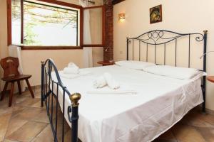 a bedroom with a large bed with white sheets at Villa Eleanto in Cefalù