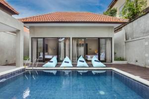 een zwembad met kussens naast een huis bij Le Cielo Resort Canggu Batu Bolong by Maviba in Canggu
