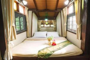 a twin bed in a room with two windows at Raisongrao Resort Khao Kho in Ban Huai Phai +204 photos