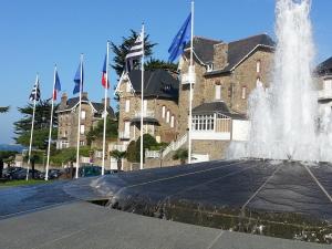 une fontaine devant un bâtiment orné de drapeaux dans l'établissement La Pause Bleue, à Dinard 6 autres photos