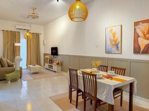 Un comedor y una sala de estar con mesa y sillas. en Family-Friendly Landed 2BR 8 Pax Netflix and WiFi, en Kamunting