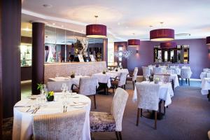 a dining room with white tables and chairs and chandeliers at 315 Bar & Restaurant in Huddersfield