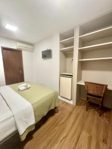 um quarto com uma cama, uma escrivaninha e uma cadeira em Hotel Natur Campeche em Florianópolis