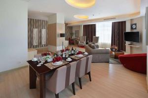 sala de estar con mesa de comedor y sala de estar en Golden Tulip Galaxy Hotel Banjarmasin, en Benuaanyar