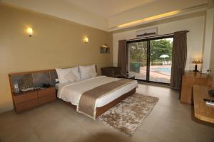 a bedroom with a large bed and a large window at VITS Kamats Resort, Silvassa in Silvassa