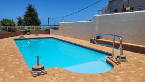 a swimming pool with blue water in a building at La Crete Sands no 3 in Uvongo Beach