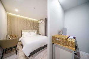 a hotel room with a bed and a chair at 광안비치호텔더엠 in Kwangan-dong