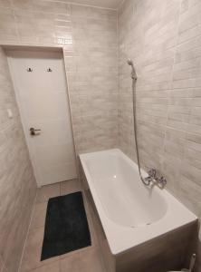 a bathroom with a tub and a shower and a sink at NassaFlat Apartman in Pécs +15 photos