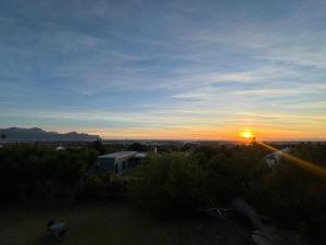 a sunset with the sun setting in the distance at Little Nest in Somerset West