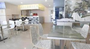 a dining room with white chairs and a table at Lovina Inn Hotel Batam in Batam Center