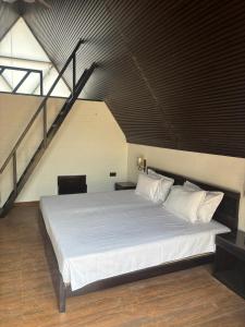 1 dormitorio con 1 cama blanca grande en un loft en THE RiYASAT SARISKA, en Ajabgarh